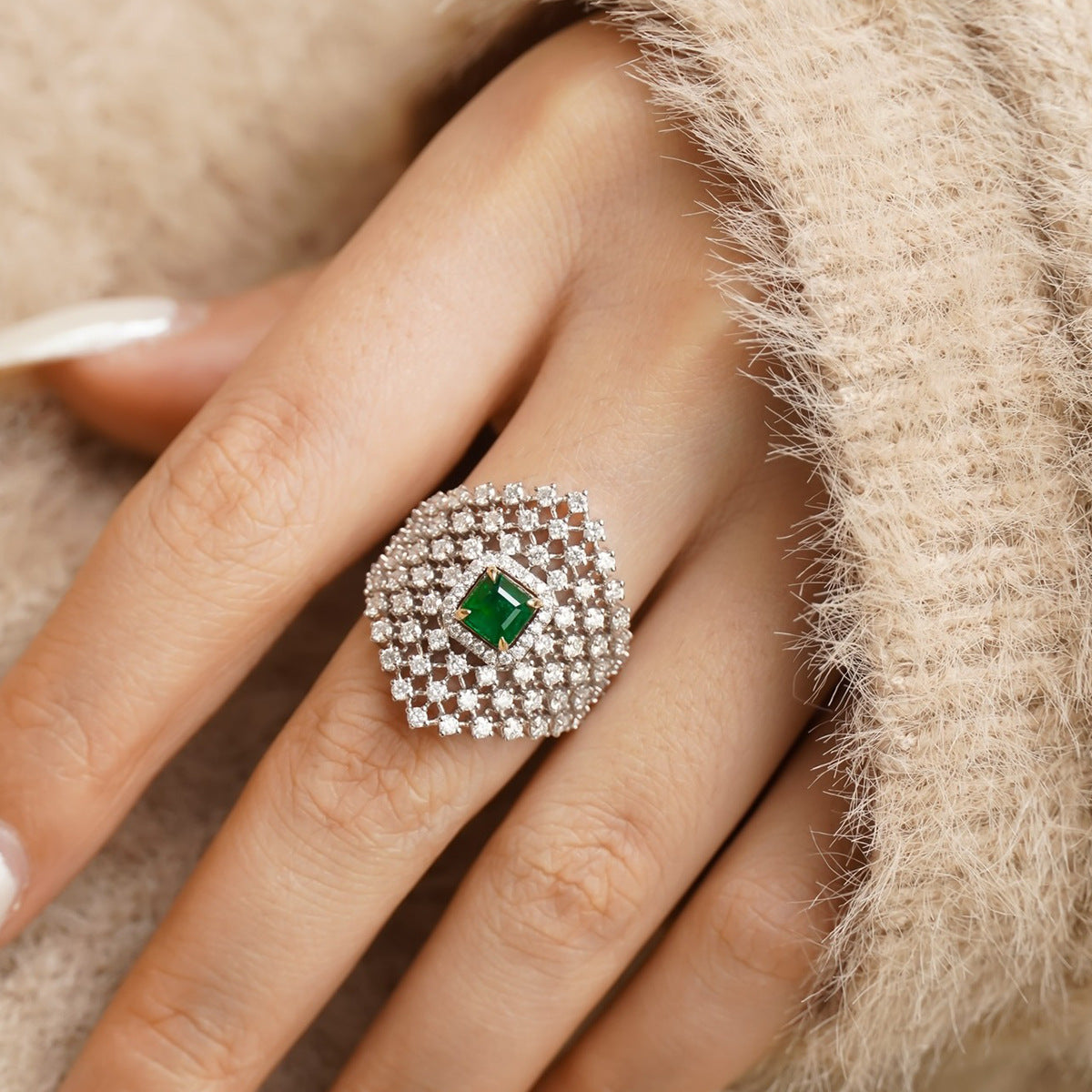 Personalized French-inspired ring with diamond inlay shown on a hand, featuring a green gemstone and geometric design.