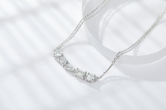 Moissanite diamond pendant in sterling silver gently resting on a surface with light shadows.